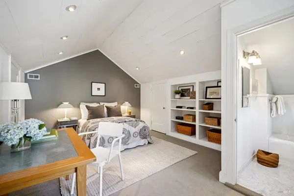 a living room with a bed furniture and next to a window