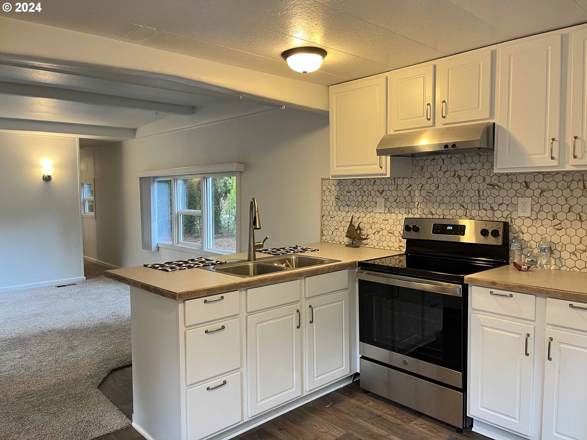 85313 Glenada Road Florence, OR 97439 - Photo 21 of 48 a kitchen with white cabinets and white appliances