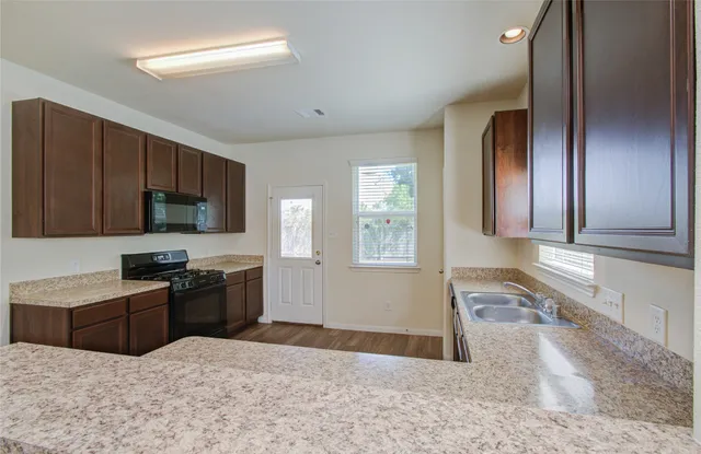 a kitchen with stainless steel appliances granite countertop a stove a sink and a refrigerator