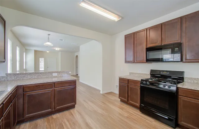 a kitchen with stainless steel appliances wooden cabinets and a stove top oven