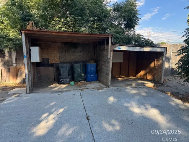 a view of a wooden house with a small yard and wooden fence