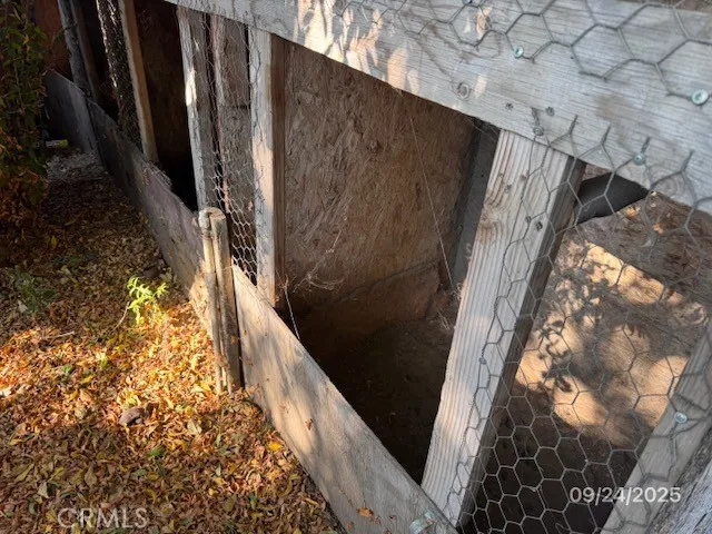 a backyard of a house with large trees and wooden fence