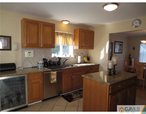 124 Disbrow Road Old Bridge, NJ 07747 - Photo 3 of 10 a kitchen with kitchen island granite countertop a sink cabinets and window