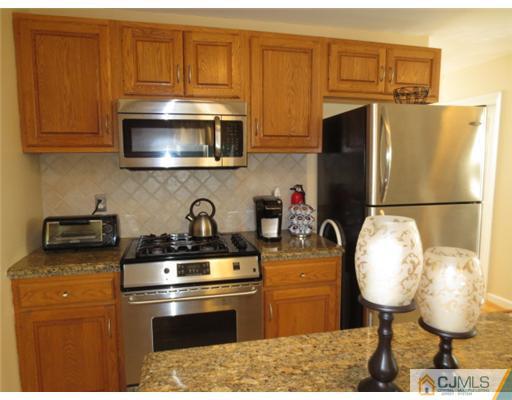 124 Disbrow Road Old Bridge, NJ 07747 - Photo 5 of 10 a kitchen with stainless steel appliances granite countertop a stove a refrigerator and a microwave