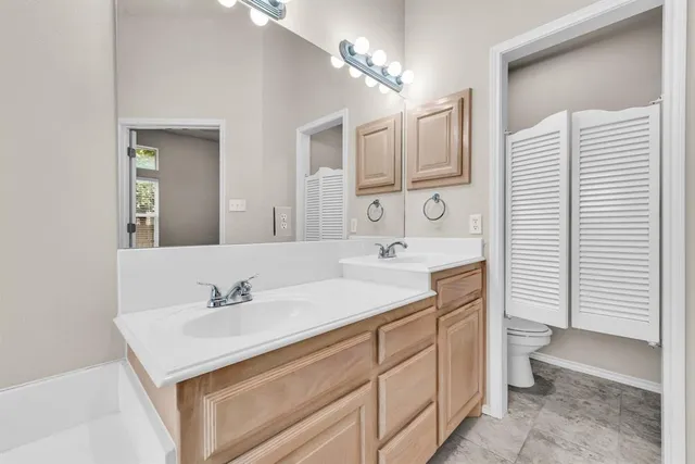 a bathroom with a sink double vanity and a toilet