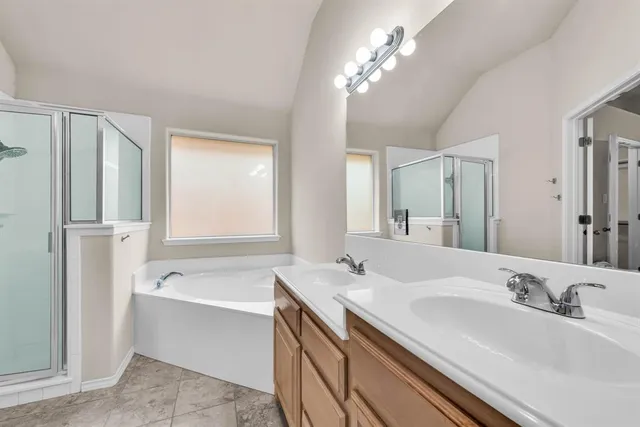 a bathroom with a tub a sink and mirror