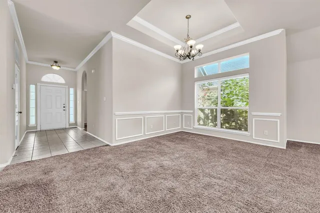 an empty room with windows and ceiling fan