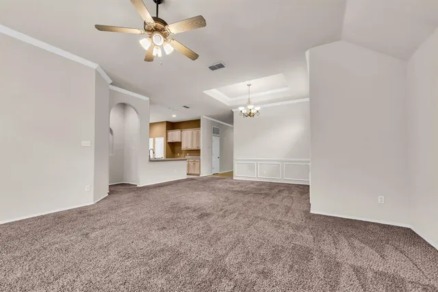 a view of a big room with chandelier fan and windows