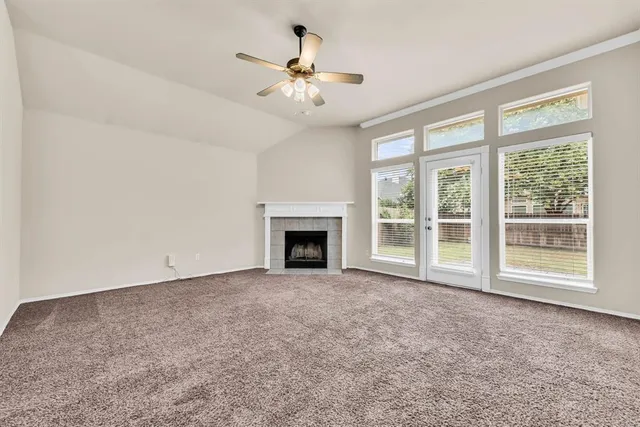 a view of an empty room with a fireplace and a window