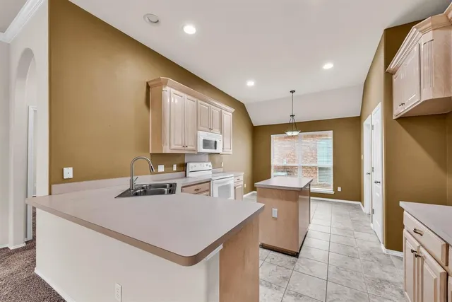 a kitchen with a sink a stove and chairs