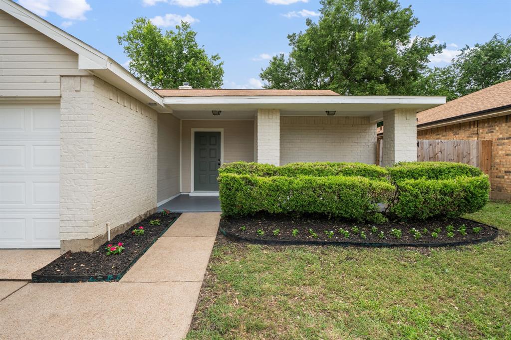 310 Valley Spring Drive Arlington, TX 76018 - Photo 3 of 24 Light-colored brick exterior with a contrasting dark front door