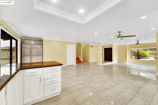 a living room with stainless steel appliances kitchen island granite countertop a sink and cabinets