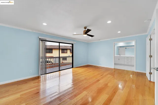 a big room with wooden floor and a ceiling fan