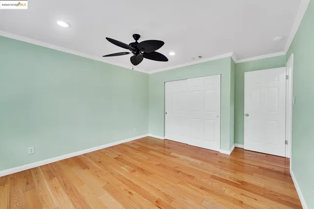 a view of a big room with wooden floor and a ceiling fan