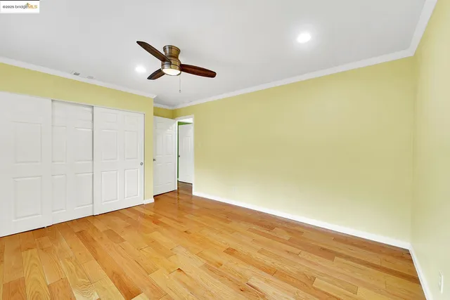a view of a big room with wooden floor and windows