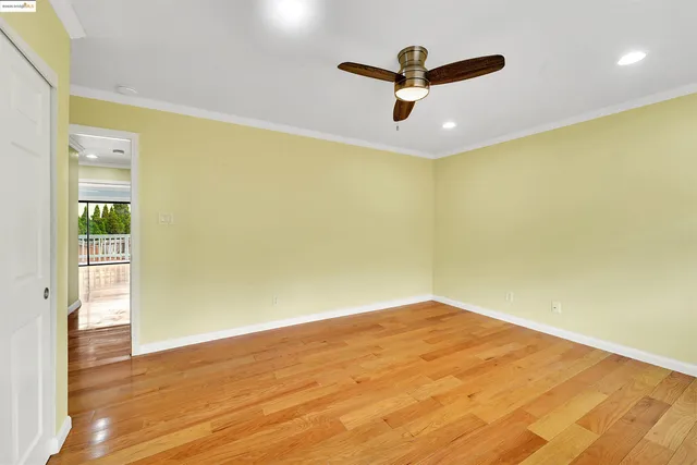 a view of a big room with wooden floor and windows