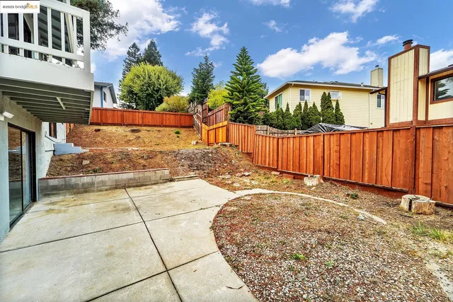 a view of a white house with a large tree