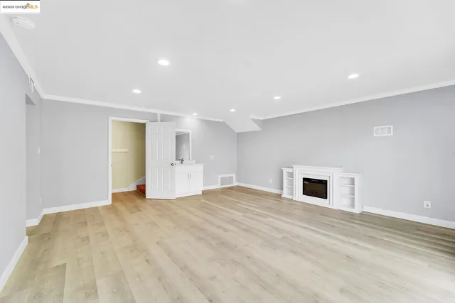 a view of empty room with wooden floor