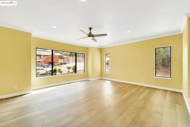a view of an empty room with a window and a ceiling fan