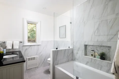 a bathroom with a bathtub sink and window