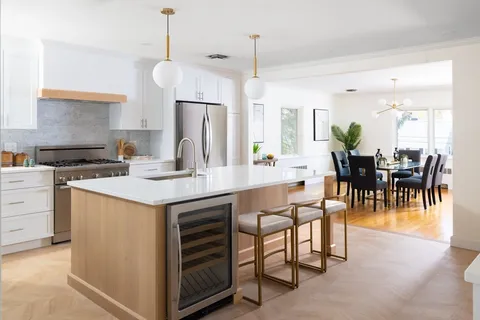 a kitchen with stainless steel appliances kitchen island granite countertop a table chairs and a refrigerator
