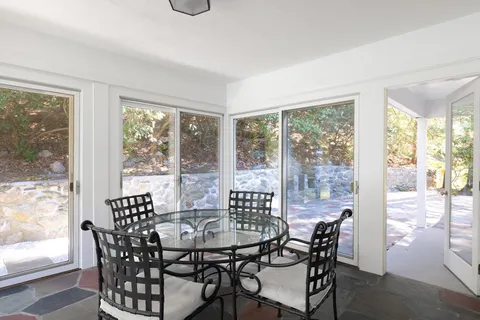 a view of a dining room with furniture large windows and wooden floor