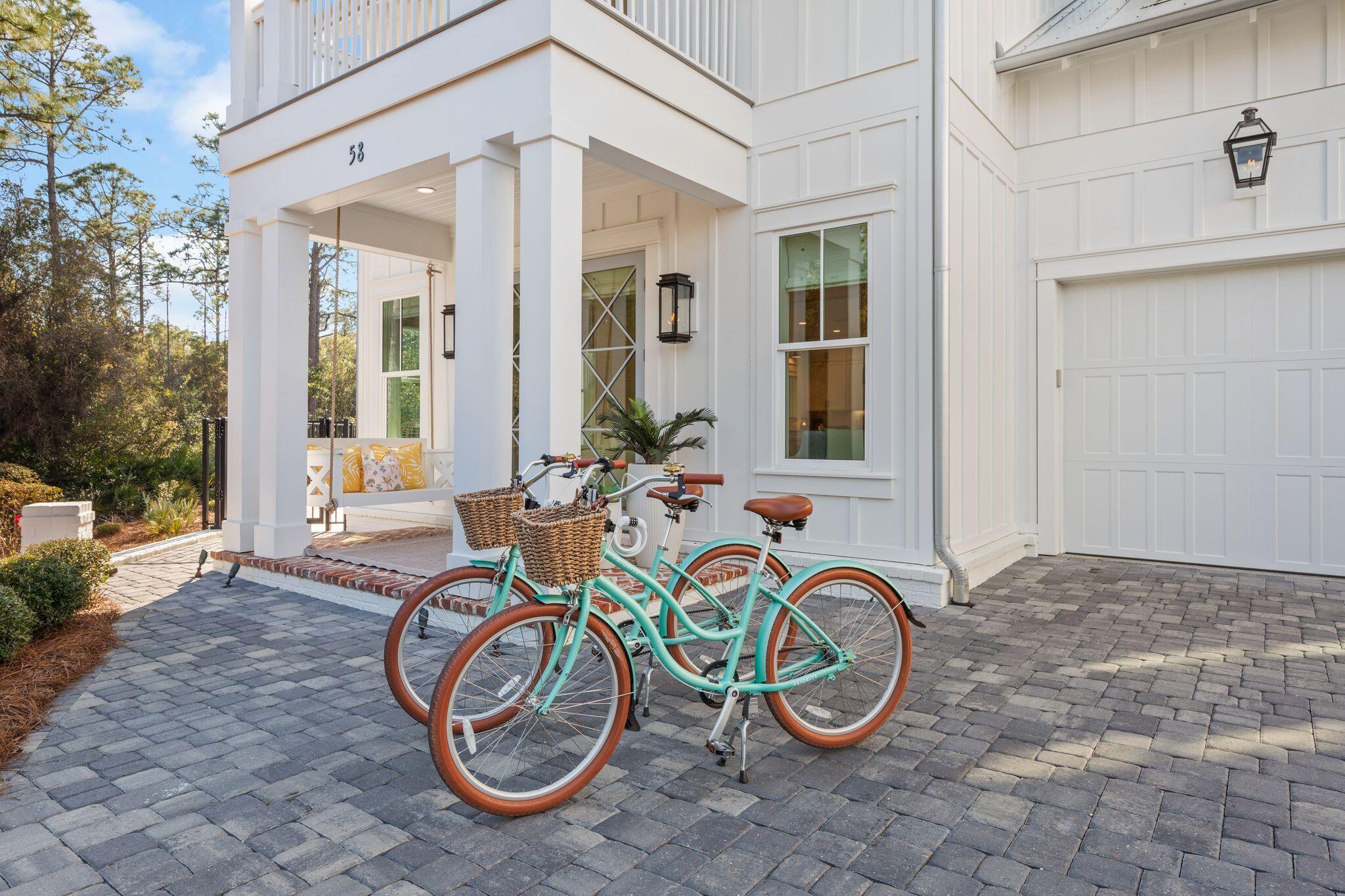 58 White Cottage Road Santa Rosa Beach, FL 32459 - Photo 2 of 84 a front view of a house with large trees and a table and chairs