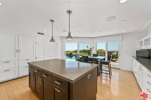 a kitchen with a stove a counter space and wooden floor