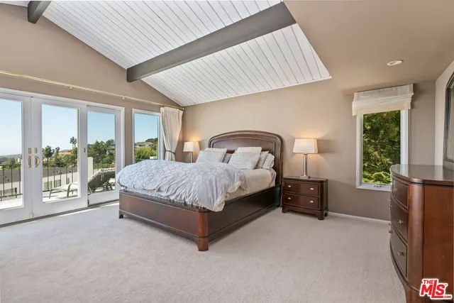 a bedroom with a large bed and a large window