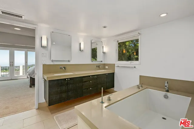 a bathroom with a tub sink and mirror