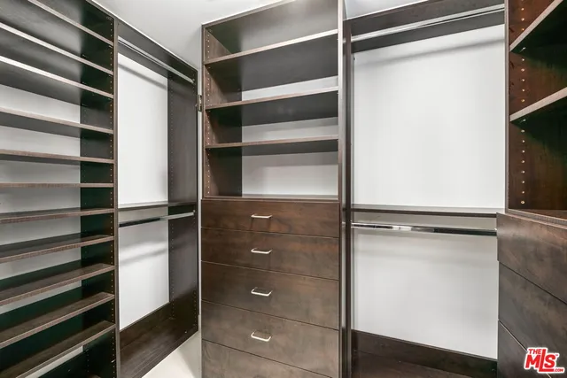 a view of walk in closet with empty racks