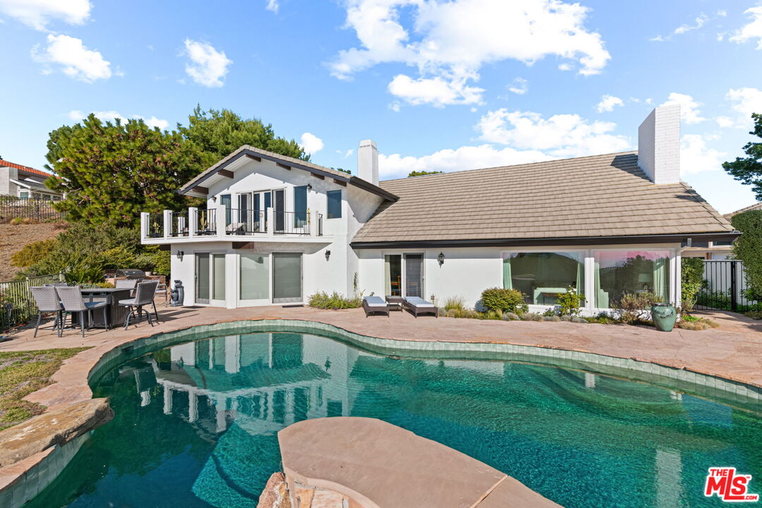 2601 Cordelia Road Los Angeles, CA 90049 - Photo 4 of 43 a front view of a house with a yard table and chairs