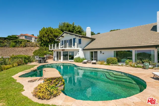 a view of a house with swimming pool and a yard