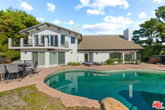 a front view of a house with swimming pool having outdoor seating