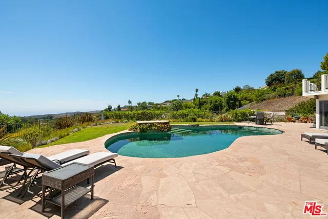 an aerial view of a swimming pool with a yard