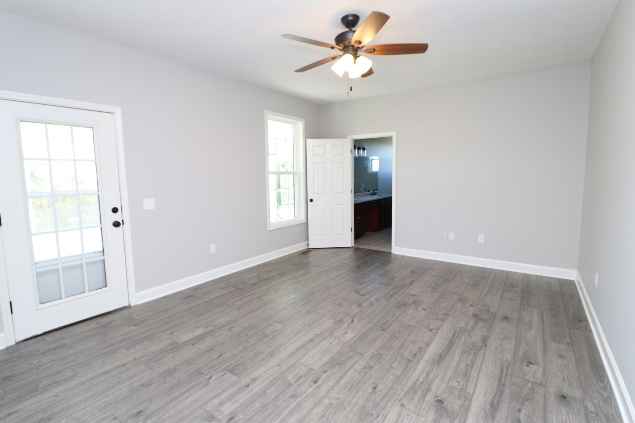 1180 Coleytown Road Lafayette, TN 37083 - Photo 17 of 42 an empty room with wooden floor fan and windows