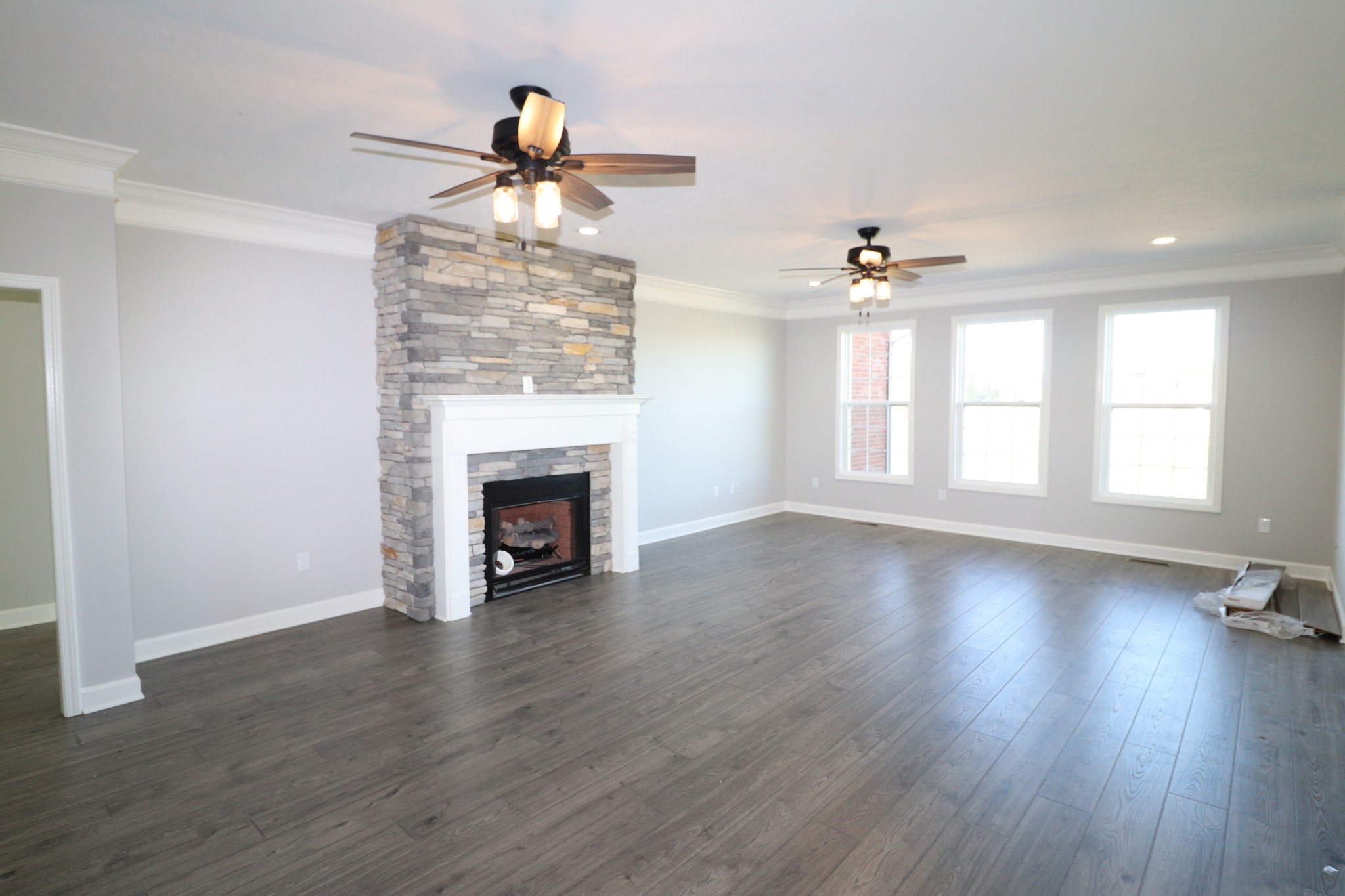 1180 Coleytown Road Lafayette, TN 37083 - Photo 6 of 42 an empty room with wooden floor fireplace and windows