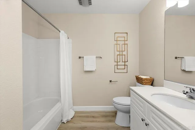 a bathroom with a granite countertop toilet a sink and a bathtub