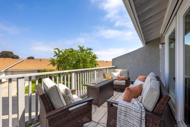 a balcony with wooden floor barbeque oven and furniture