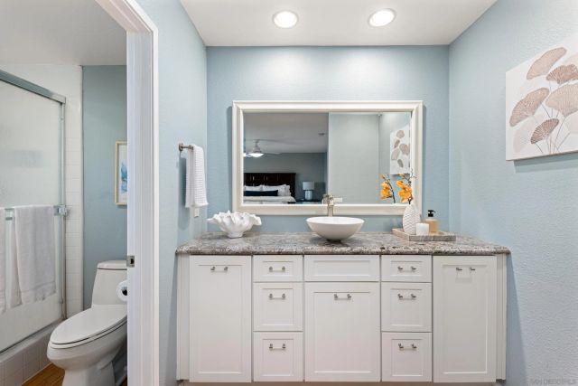 a bathroom with a granite countertop sink and a mirror