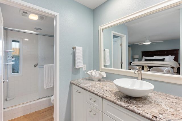 a bathroom with a granite countertop sink and a mirror