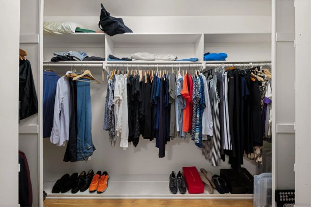 a view of walk in closet with clothes and shoes