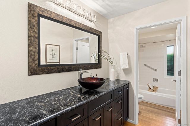 a bathroom with a granite countertop sink and a mirror