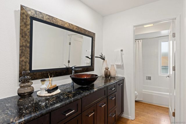 a bathroom with a granite countertop sink and a mirror