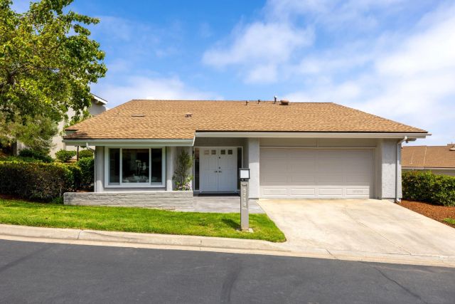 a front view of a house with a yard and potted plants
