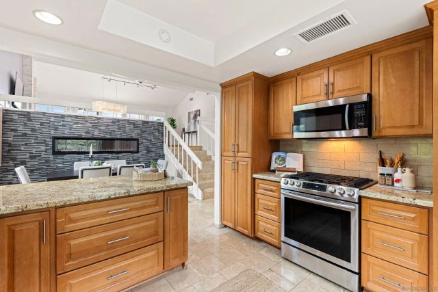 a kitchen with stainless steel appliances granite countertop a stove microwave and refrigerator