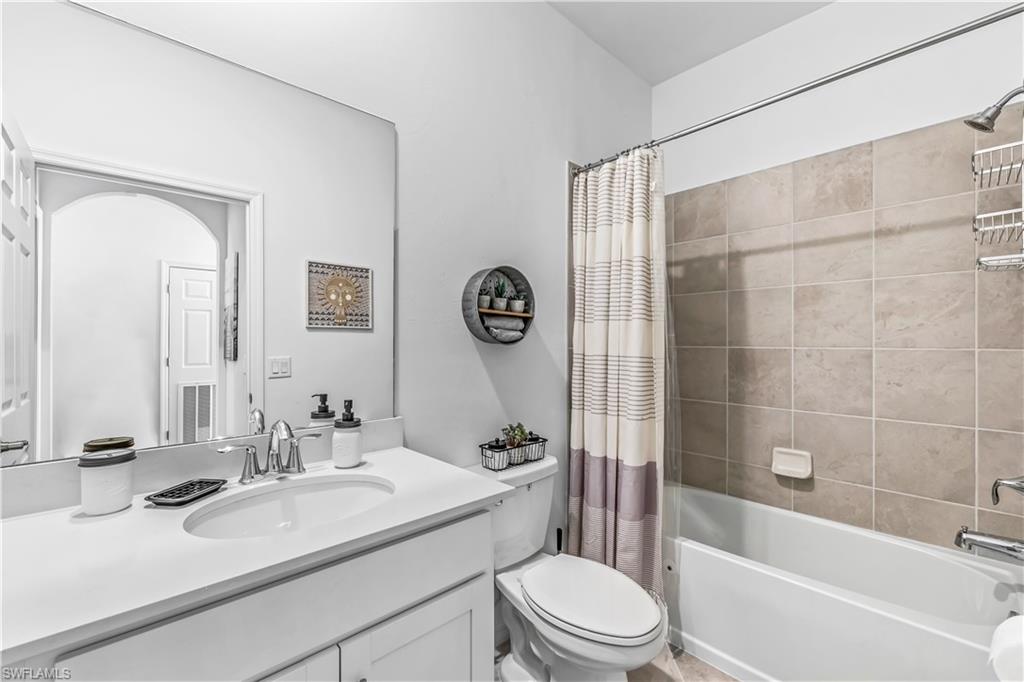 43989 Boardwalk Loop, Unit 2046 Babcock Ranch, FL 33982 - Photo 12 of 12 a bathroom with a sink a toilet a mirror a vanity a bathtub and shower