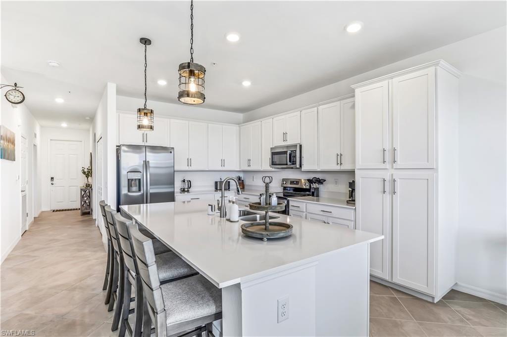 43989 Boardwalk Loop, Unit 2046 Babcock Ranch, FL 33982 - Photo 3 of 12 a kitchen with stainless steel appliances kitchen island granite countertop a sink a stove a refrigerator and white cabinets