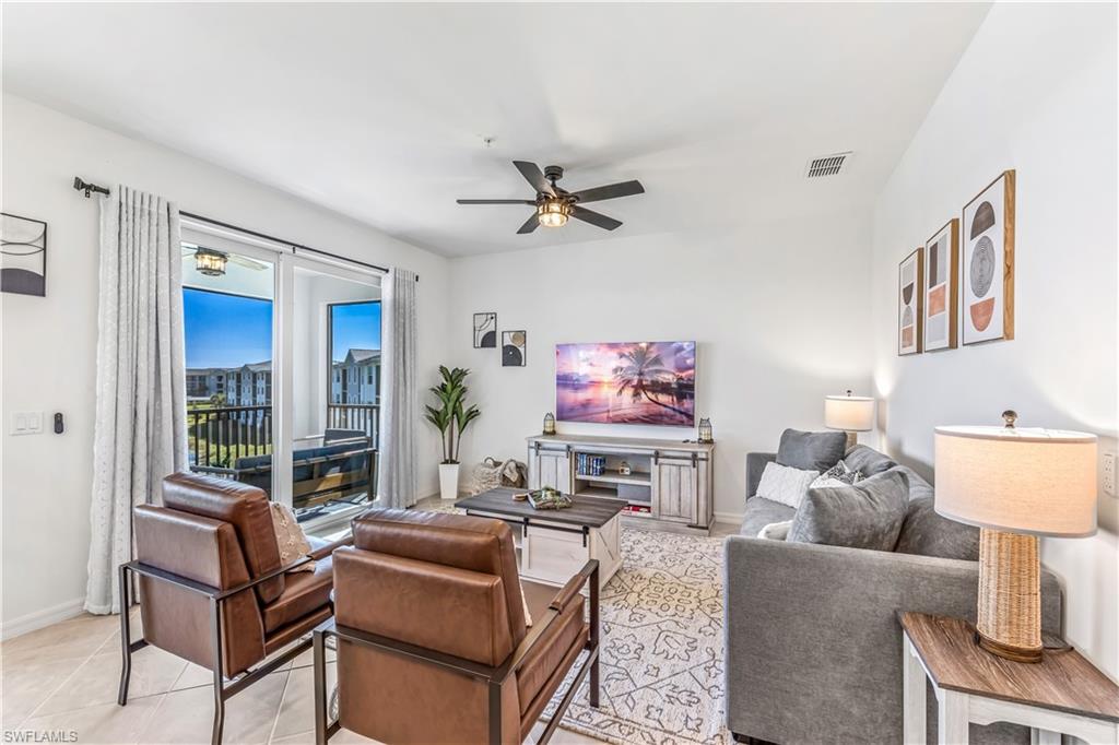 43989 Boardwalk Loop, Unit 2046 Babcock Ranch, FL 33982 - Photo 6 of 12 a living room with furniture a flat screen tv and a window