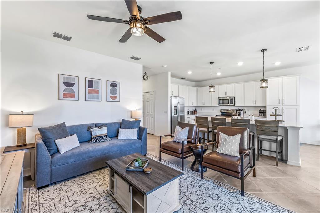 43989 Boardwalk Loop, Unit 2046 Babcock Ranch, FL 33982 - Photo 7 of 12 a living room with furniture kitchen view and a chandelier